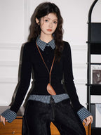 Model wearing a black long-sleeved top with a checkered collar and cuffs, paired with dark wash wide-leg jeans and a brown crossbody bag.