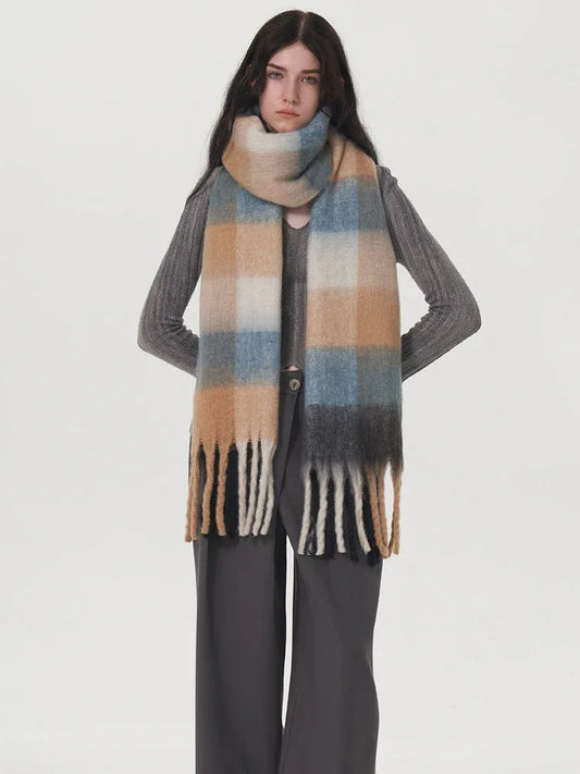 Front view of a model wearing a grey sweater and plaid scarf