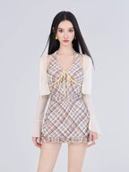 Woman wearing a plaid halter dress with a sheer cropped cardigan