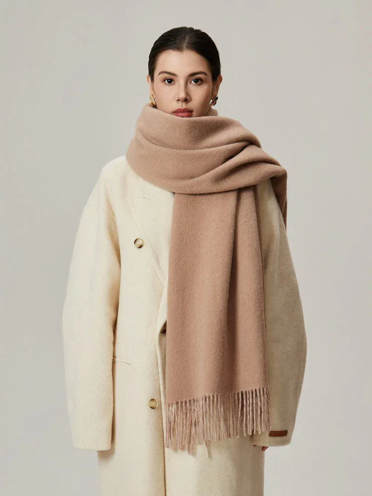 Woman wearing a cream coat and a solid beige scarf