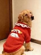 Golden retriever dog sitting and wearing a red fleece sweater