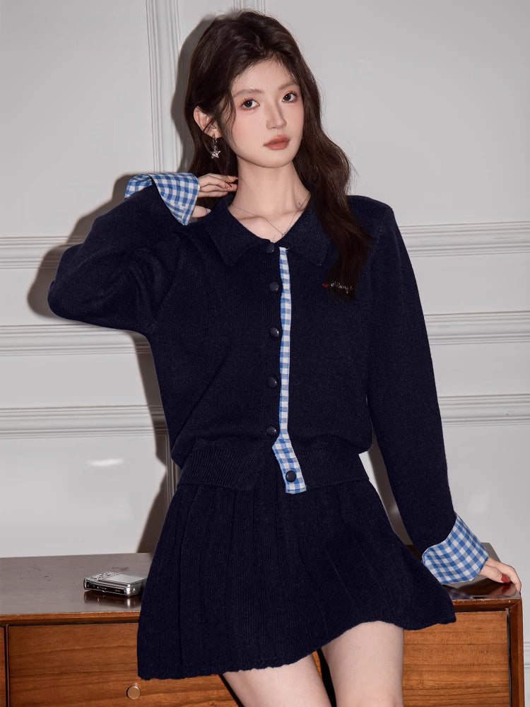 Close-up of a woman wearing a navy blue knit cardigan with gingham trim and a matching skirt.