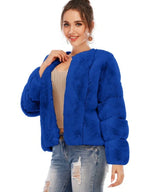 Close-up of a woman in a royal blue faux fur jacket, smiling and adjusting the jacket.