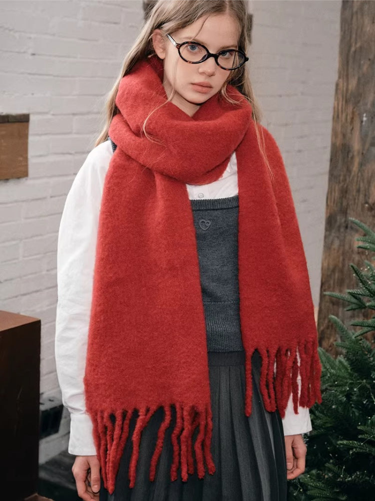 Close-up of a woman wearing a red oversized scarf with fringed ends