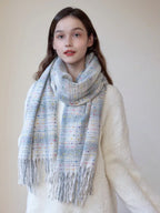 Close-up of a young woman wearing a plaid scarf with colorful flecks and fringe.