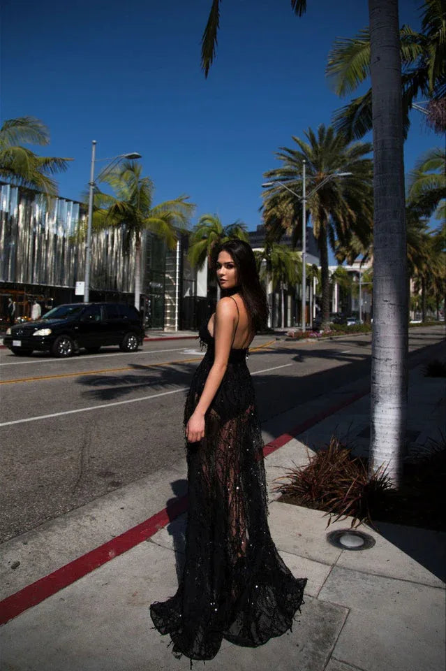 woman standing on a sidewalk in a black sequined gown