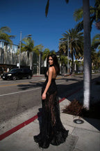 woman standing on a sidewalk in a black sequined gown