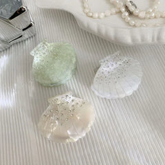 three seashell hair clips with rhinestones and glitter in various colors