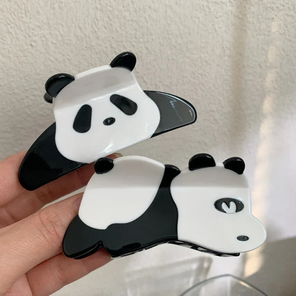 Two panda hair claw clips held in a hand
