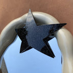 black glitter star hair clip attached to a decorative mirror frame