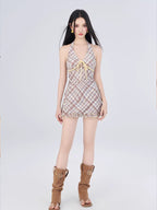 Woman in a plaid halter dress and brown boots