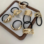 Assortment of gold-tone abstract shape hair ties arranged in a tray