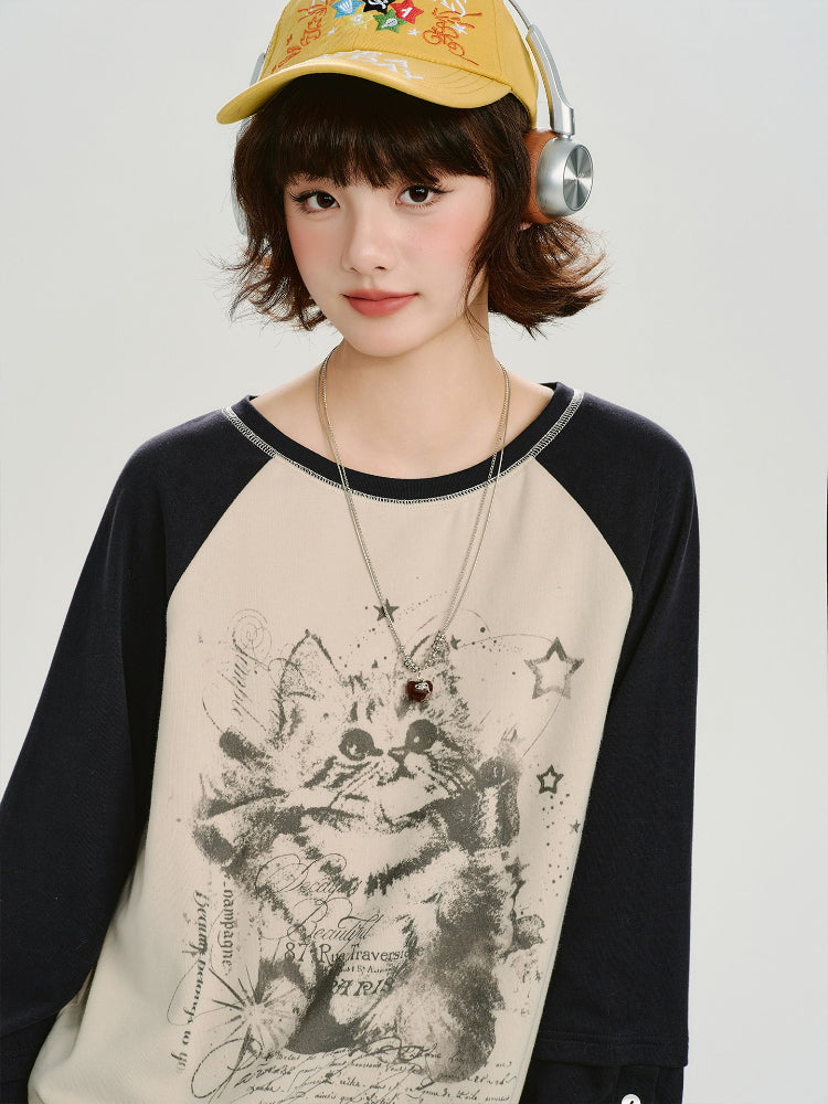 Close-up of the model's face and the graphic print on the shirt, featuring a cat illustration and text.