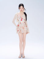 Full body shot of a woman in a floral print mini dress and cardigan
