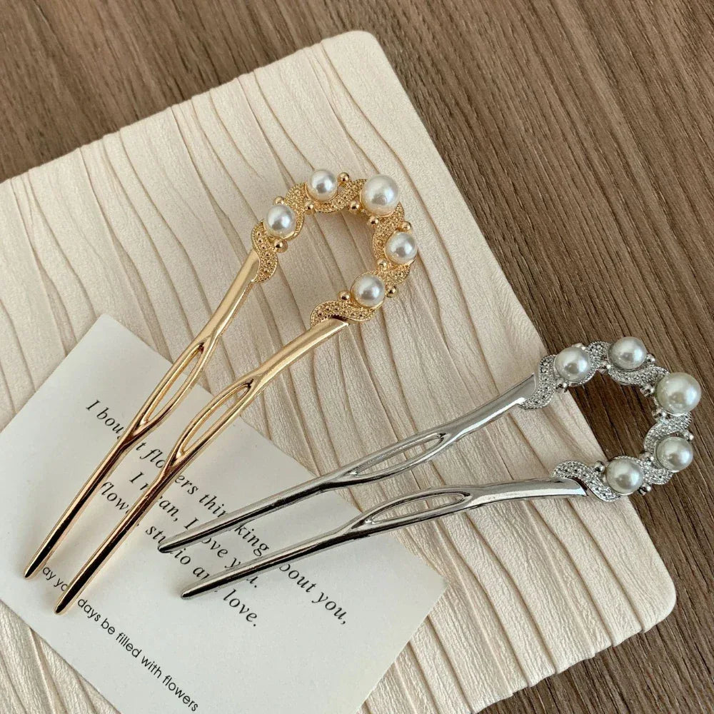Gold and silver hairpins with pearl and rhinestone embellishments on a textured fabric