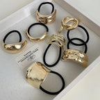 Collection of gold-tone abstract shape hair ties in a tray
