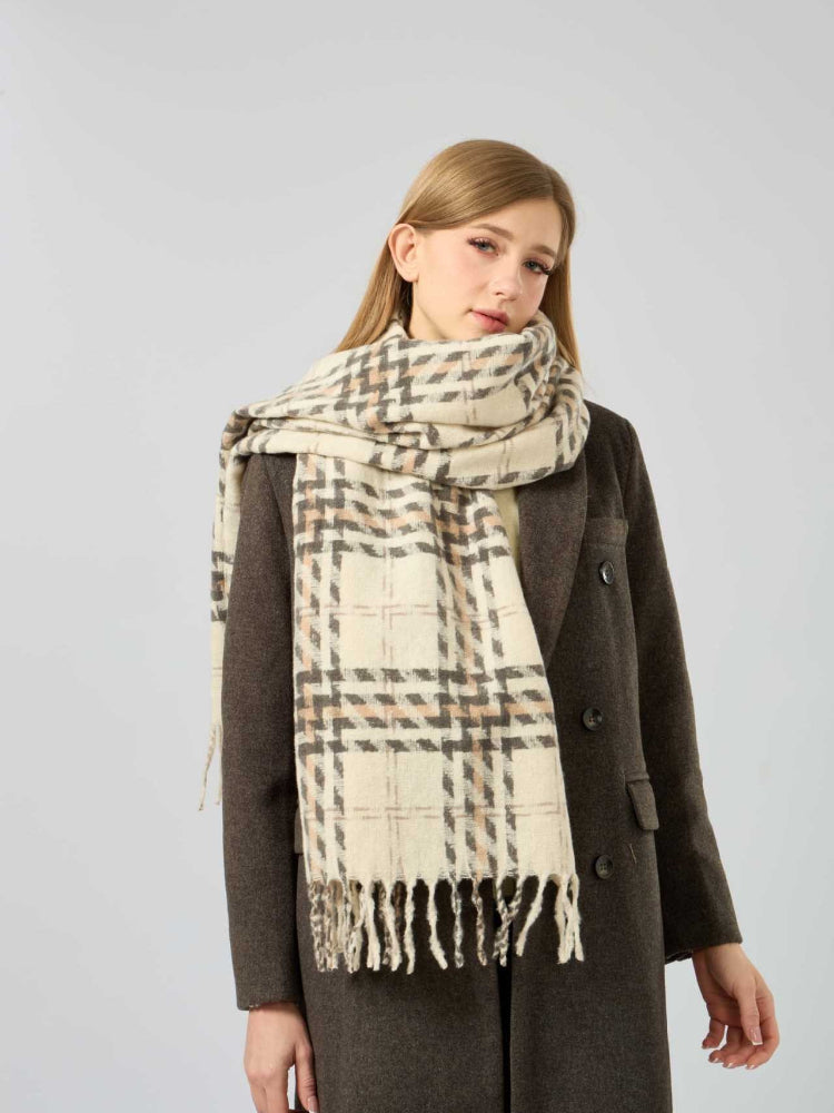 Woman in a brown coat with a cream, brown, and grey plaid scarf around her neck