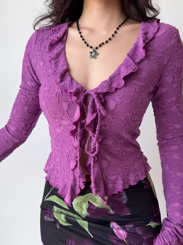 Close-up of a purple floral lace long-sleeve top with a tie-front closure.