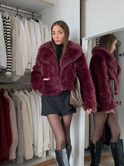 Woman wearing a burgundy faux fur jacket with a black mini skirt and black boots