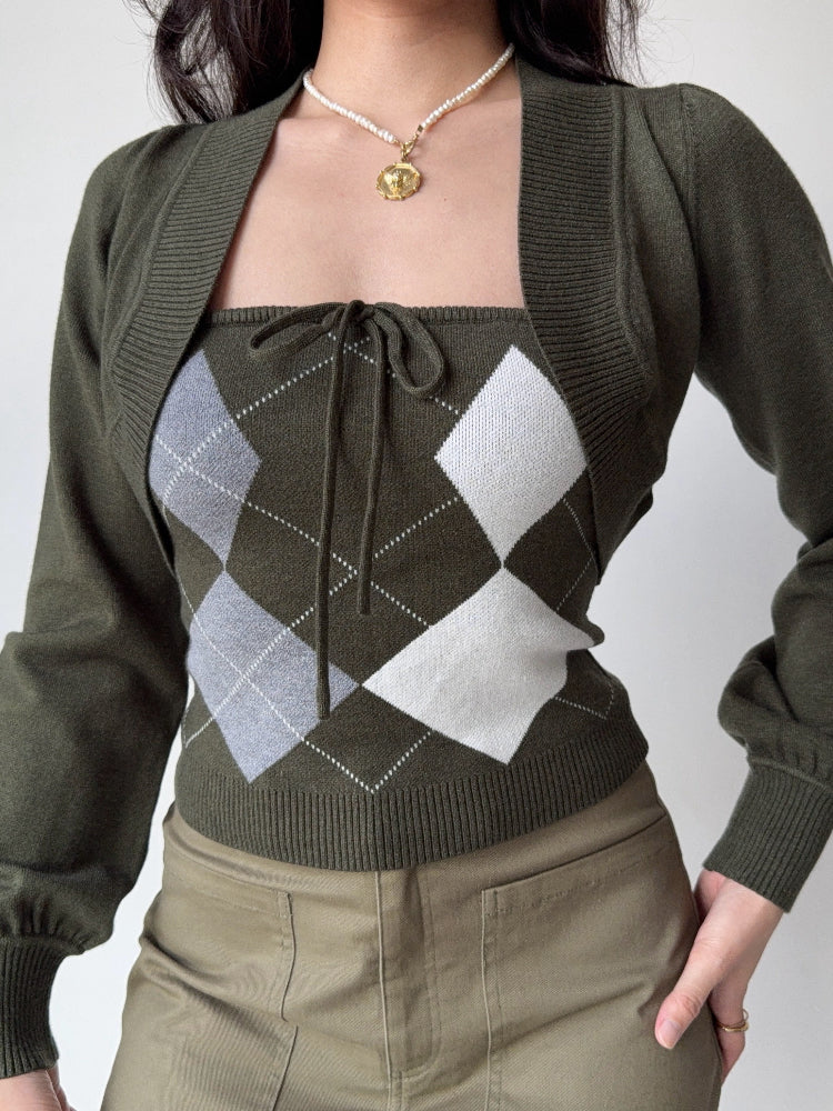 Detail shot of a woman's outfit: green argyle knit tube top with tie-front and a cropped green bolero cardigan.