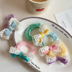Assortment of pastel scrunchies with bows and lace trim on a plate