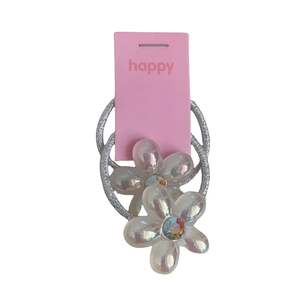Close-up of a sparkly flower hair tie with iridescent petals and a colorful gem center.