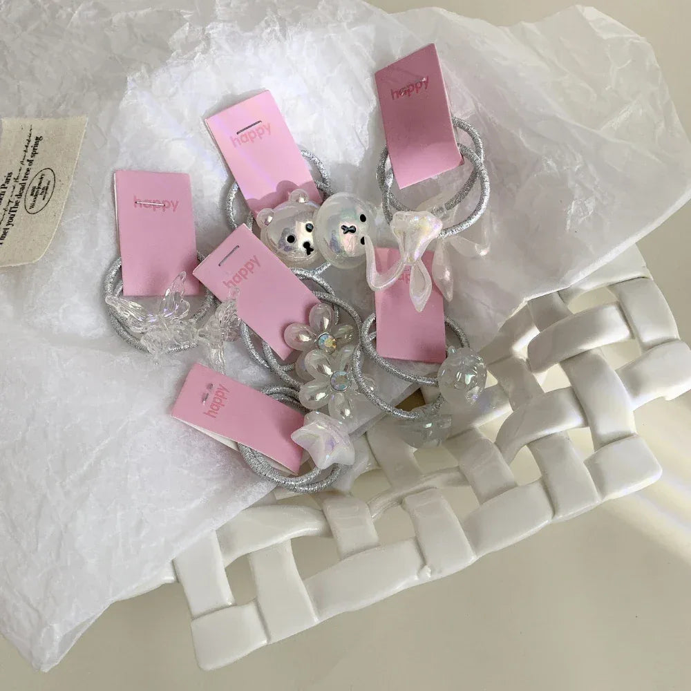 A group of decorative hair ties with unique charms, nestled in a white woven basket.