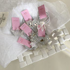 A group of decorative hair ties with unique charms, nestled in a white woven basket.