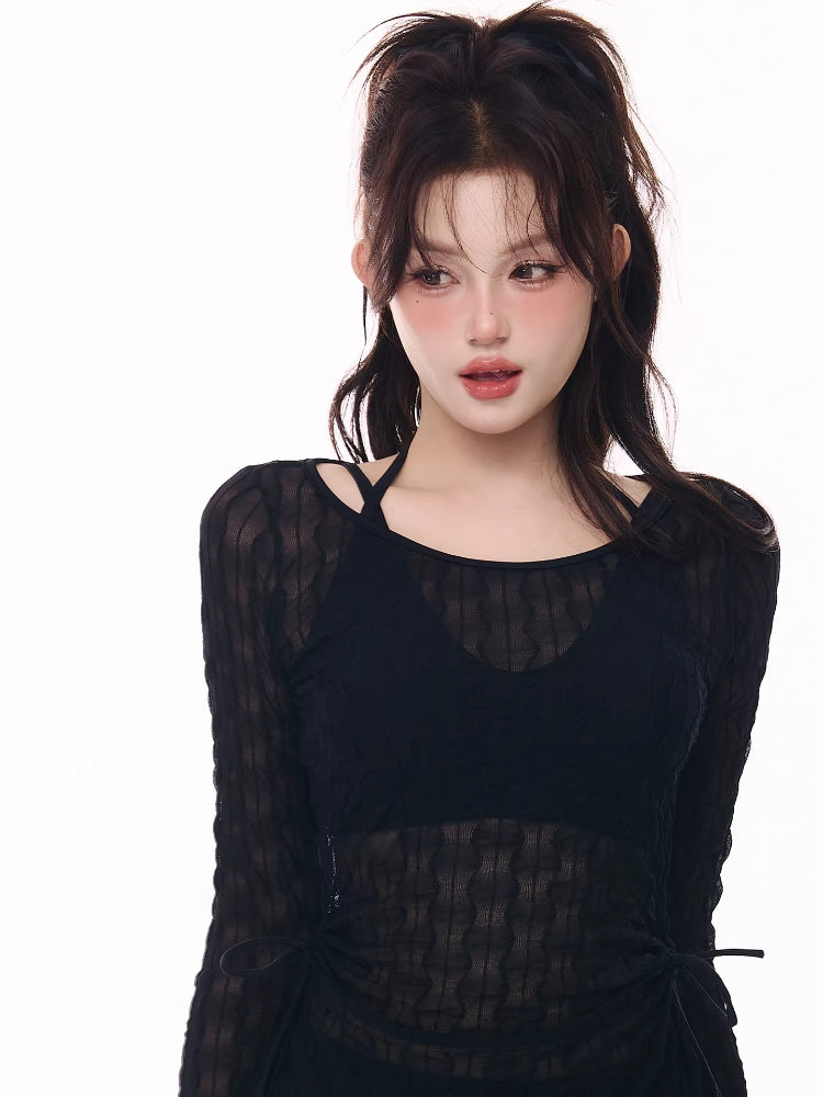 Close-up of a model wearing a black sheer long-sleeve top.