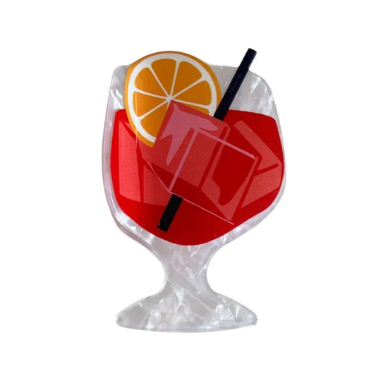 acrylic cocktail hair clip featuring a red drink with orange garnish and ice cubes