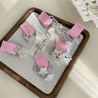 A variety of playful hair accessories, including flower, bear, and star designs, arranged on a tray.