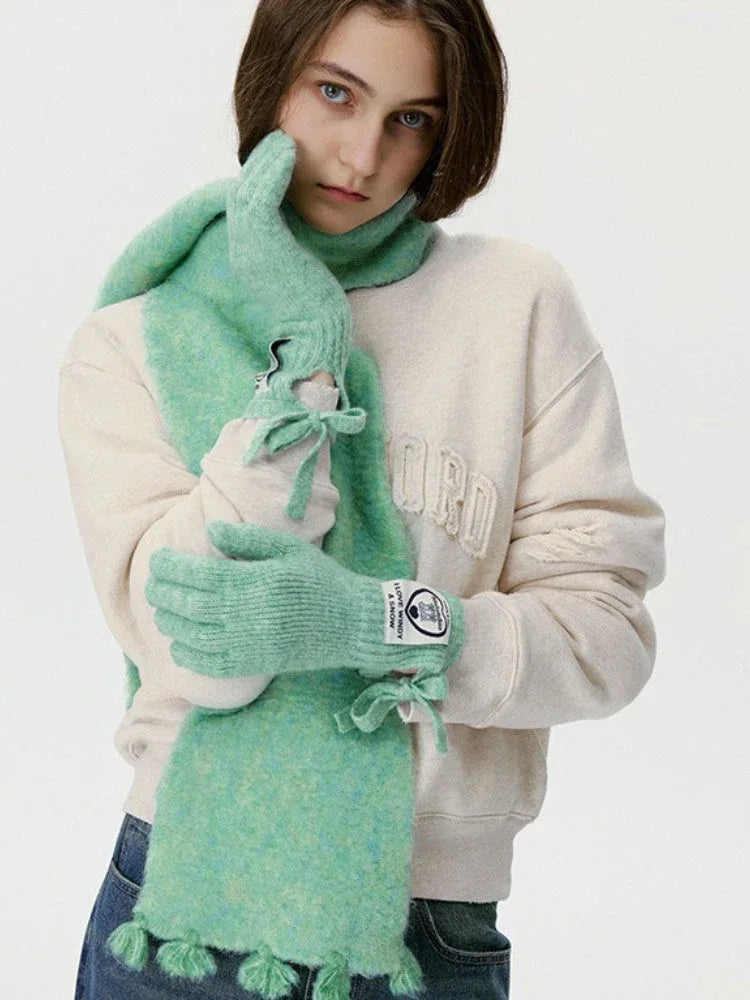 Model adjusting a mint green fuzzy scarf