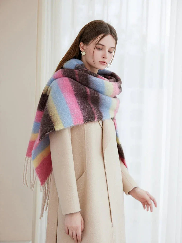 Front view of a woman wearing a colorful striped scarf and a beige coat.