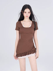 Front view of the woman in the brown swimsuit, highlighting the ruched detailing on the side and the ruffled hem.
