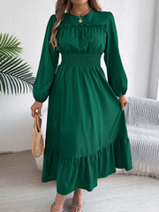 woman holding a straw bag while wearing a long green dress