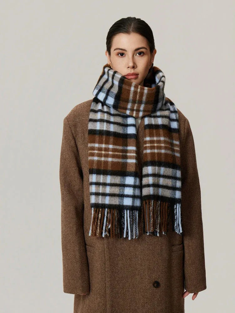 Woman wearing a brown plaid scarf with blue and black accents, draped over a brown coat. Main image