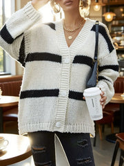 Close-up of a woman in a white and black striped knit cardigan, holding a coffee cup.