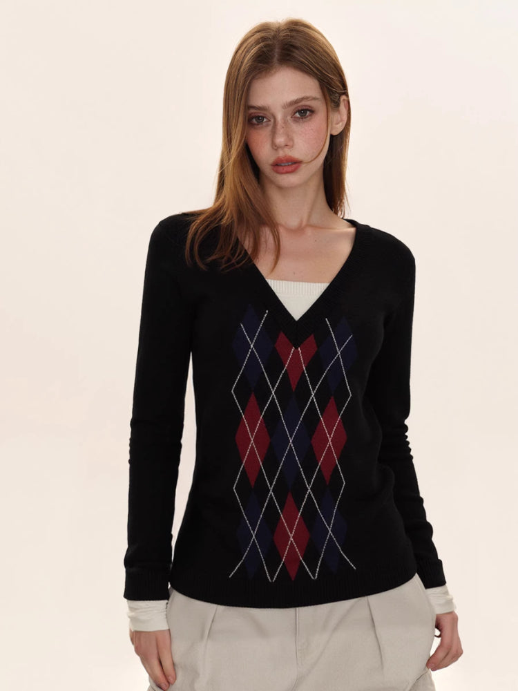 Woman wearing a black argyle v-neck sweater with a white undershirt and light-colored cargo pants.