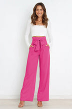woman wearing high waist wide leg pink pants with white long sleeve crop top