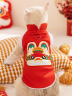 Rear view of a cat wearing a red Chinese-style vest with a rabbit design on the back.