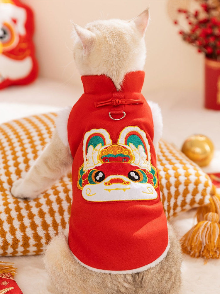 Rear view of a cat wearing a red Chinese-style vest with a rabbit design on the back.
