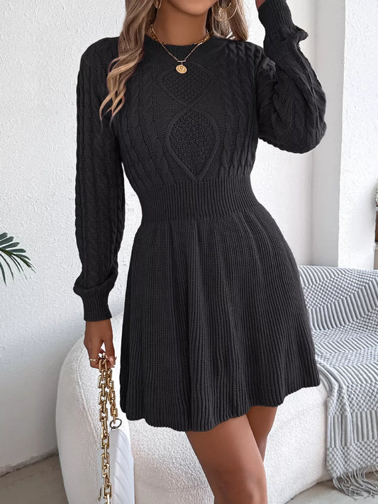 Woman wearing a black long-sleeved knit dress with cable knit detailing, holding a gold chain purse.