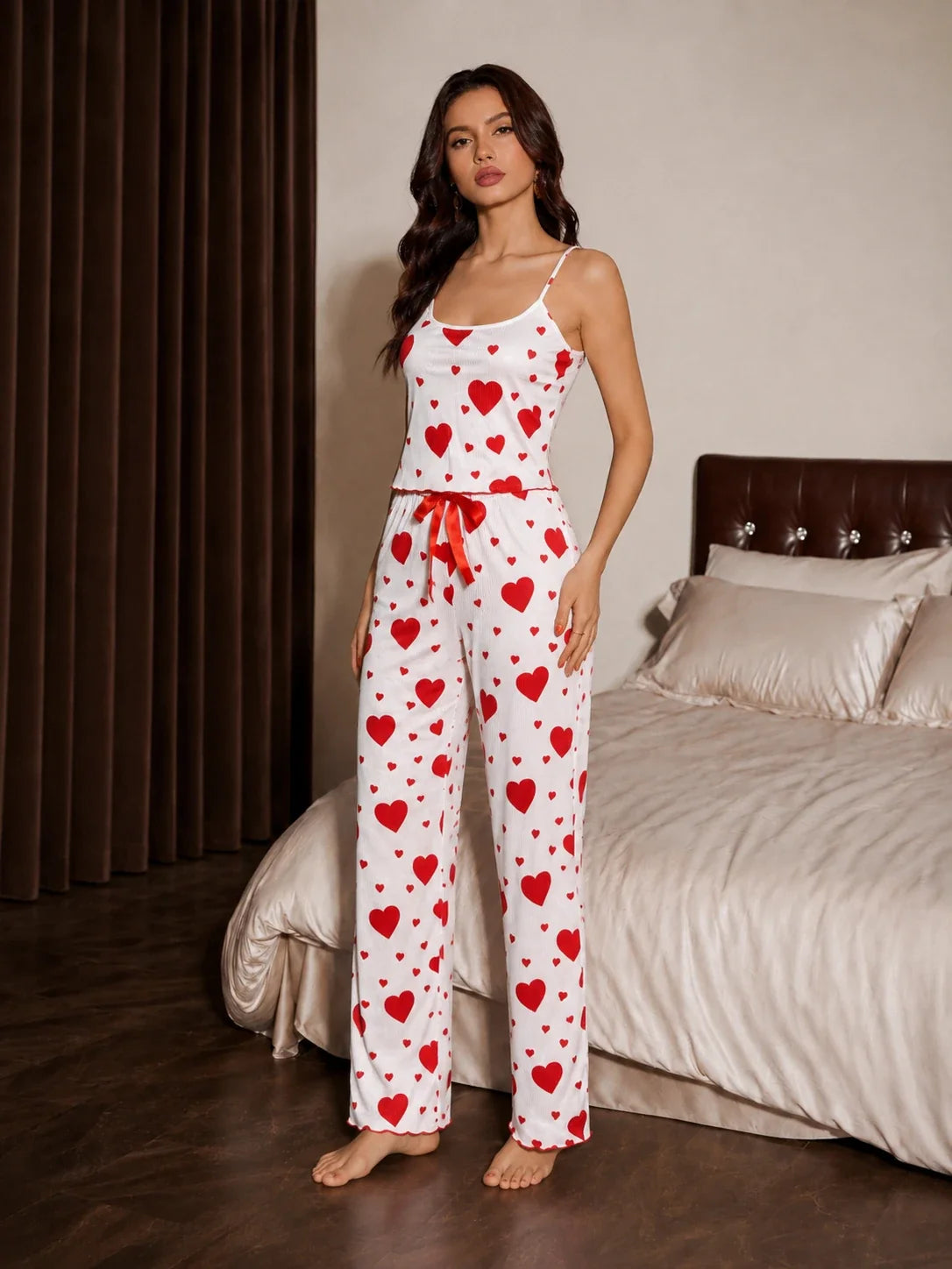 Woman posing in a two-piece heart print pajama set.