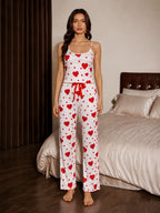 Full body shot of a woman in a heart patterned cami and pant pajama set.
