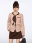 Model wearing a pink knit cardigan with brown trim and a floral scarf.