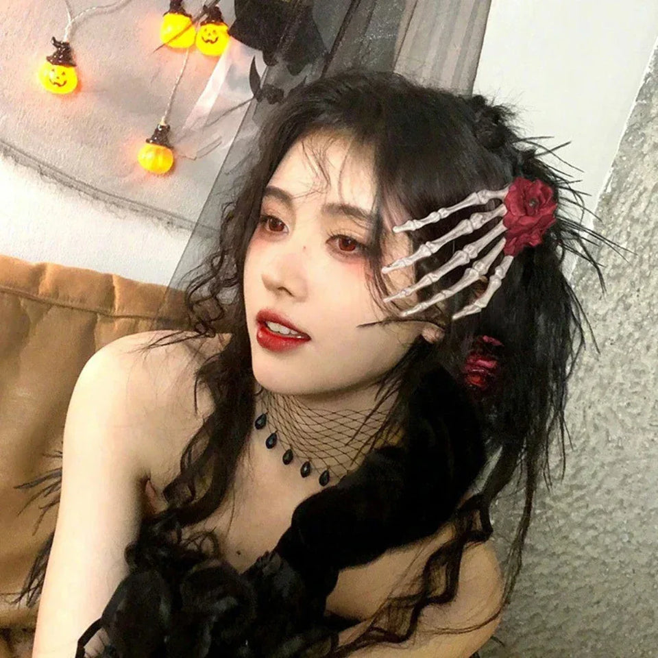 Woman with black hair wearing a skeleton hand hair clip with a red flower Secondary image