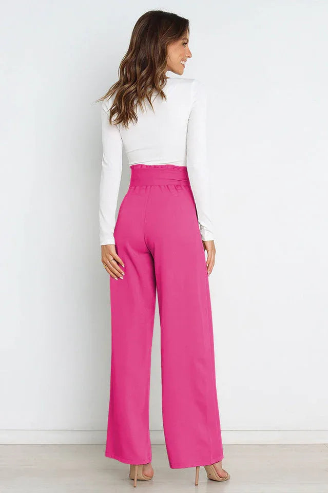back view of woman wearing high waist wide leg pink pants with white long sleeve crop top Secondary image