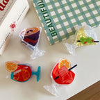 close-up of four acrylic cocktail hair clips on a white table, showcasing different drink styles