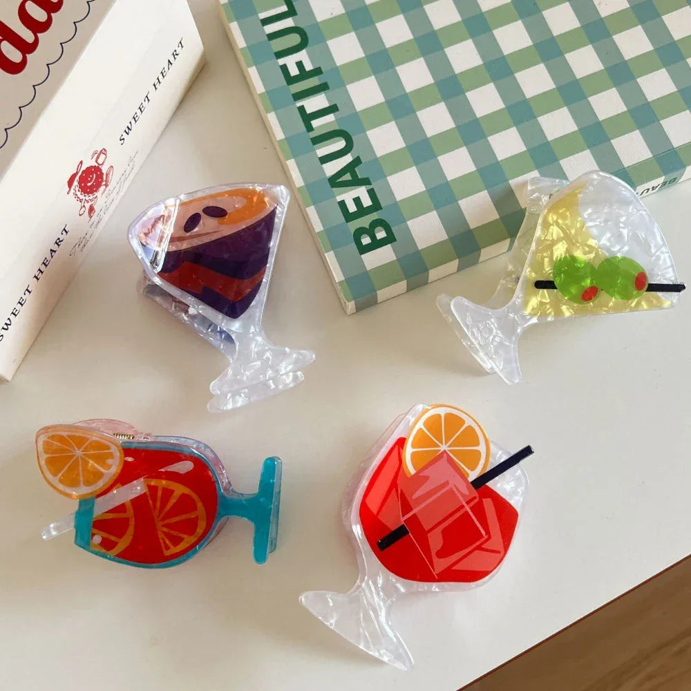 close-up of four acrylic cocktail hair clips on a white table, showcasing different drink styles