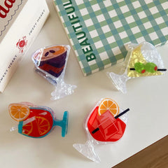 close-up of four acrylic cocktail hair clips on a white table, showcasing different drink styles